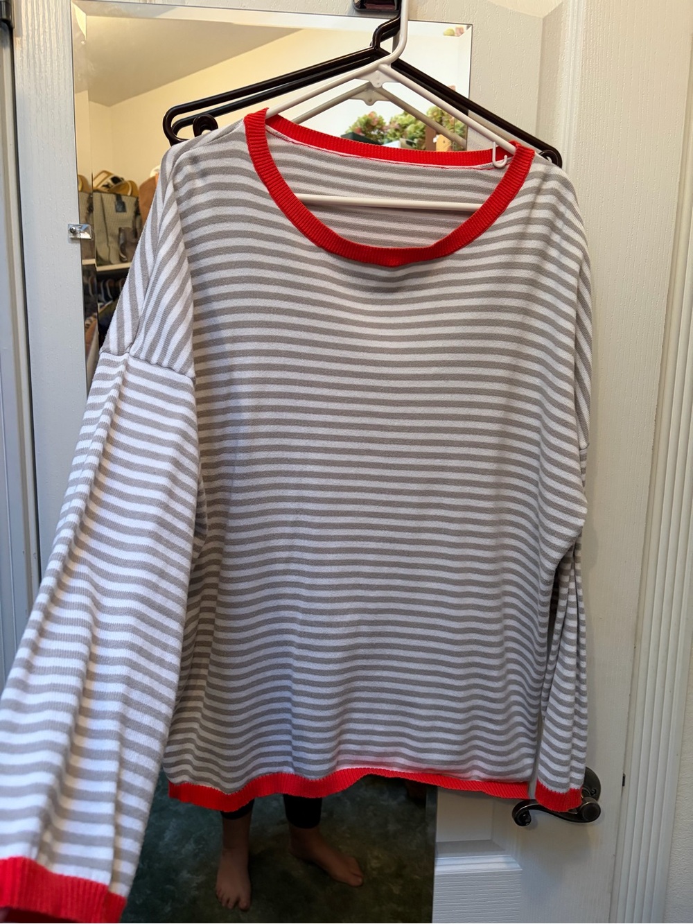 Grey and white sweater with red trim.